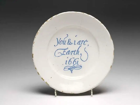 White plate with blue text 'You & I are Earth 1661' on a gray background